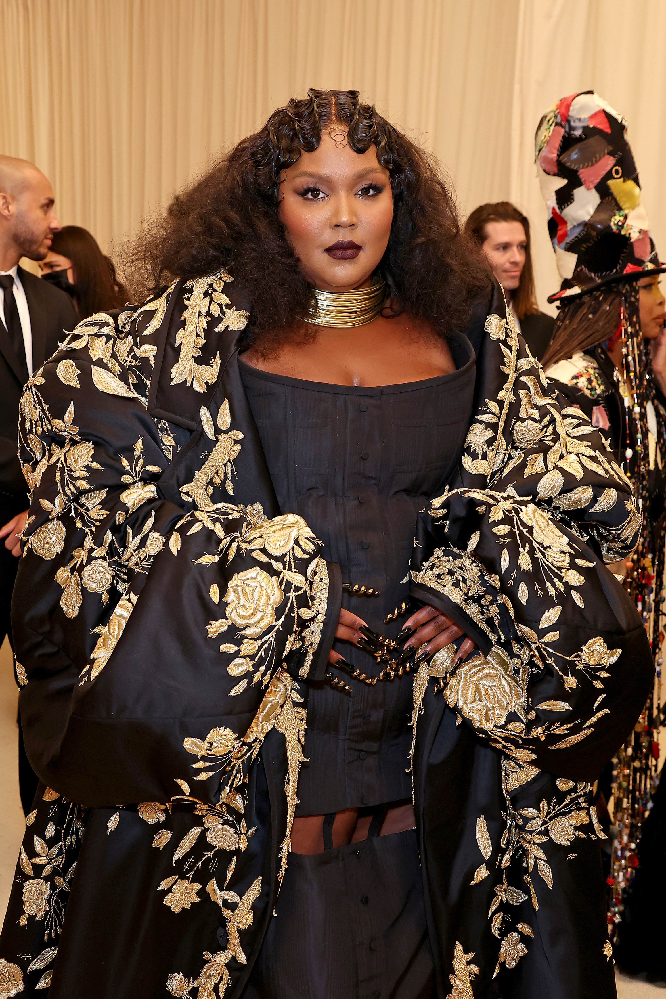 Close-up of Lizzo at the Met Gala in a corseted dress and embroidered matching duster coat