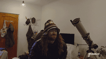 gif of a man throwing an oversized backpack over his shoulder