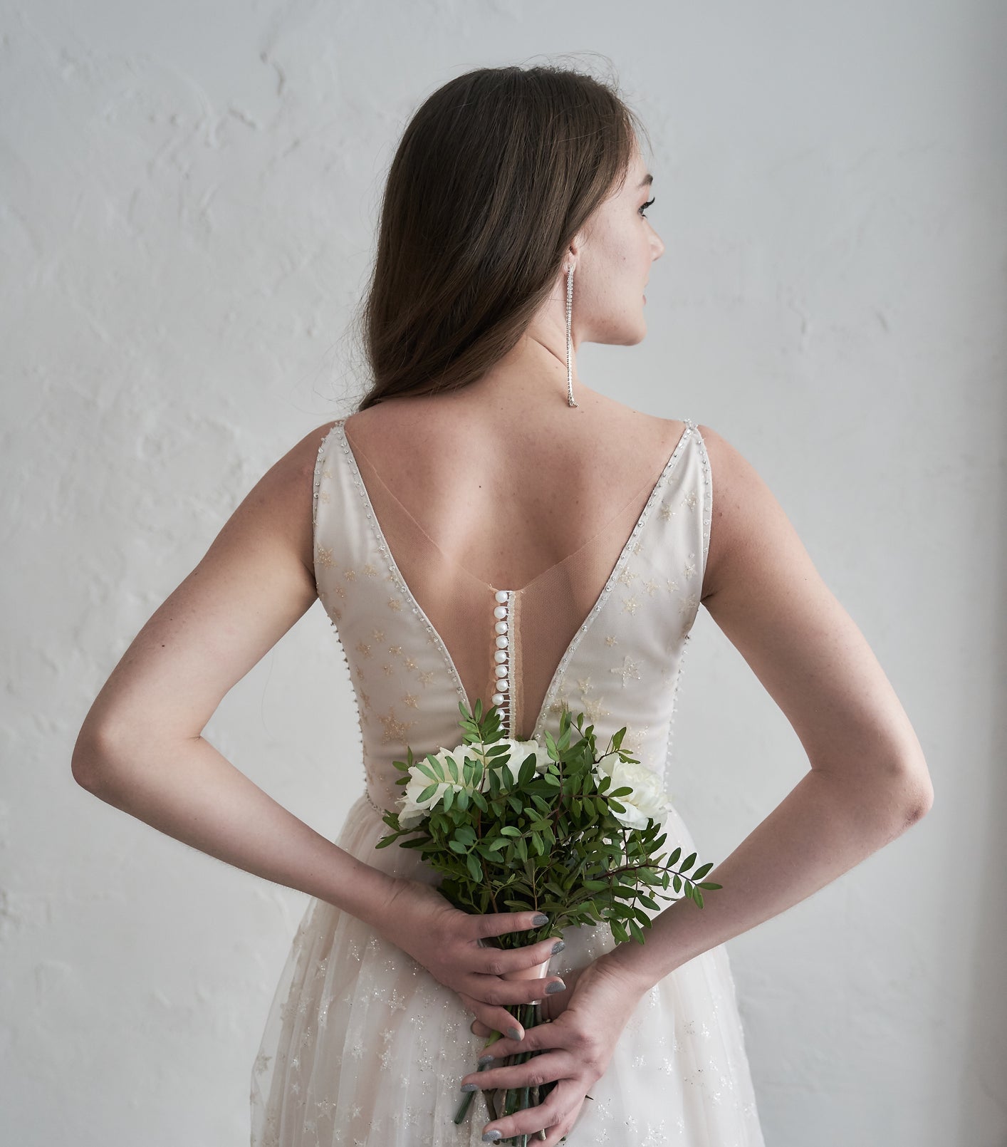 bride holding a bouquet behind her back