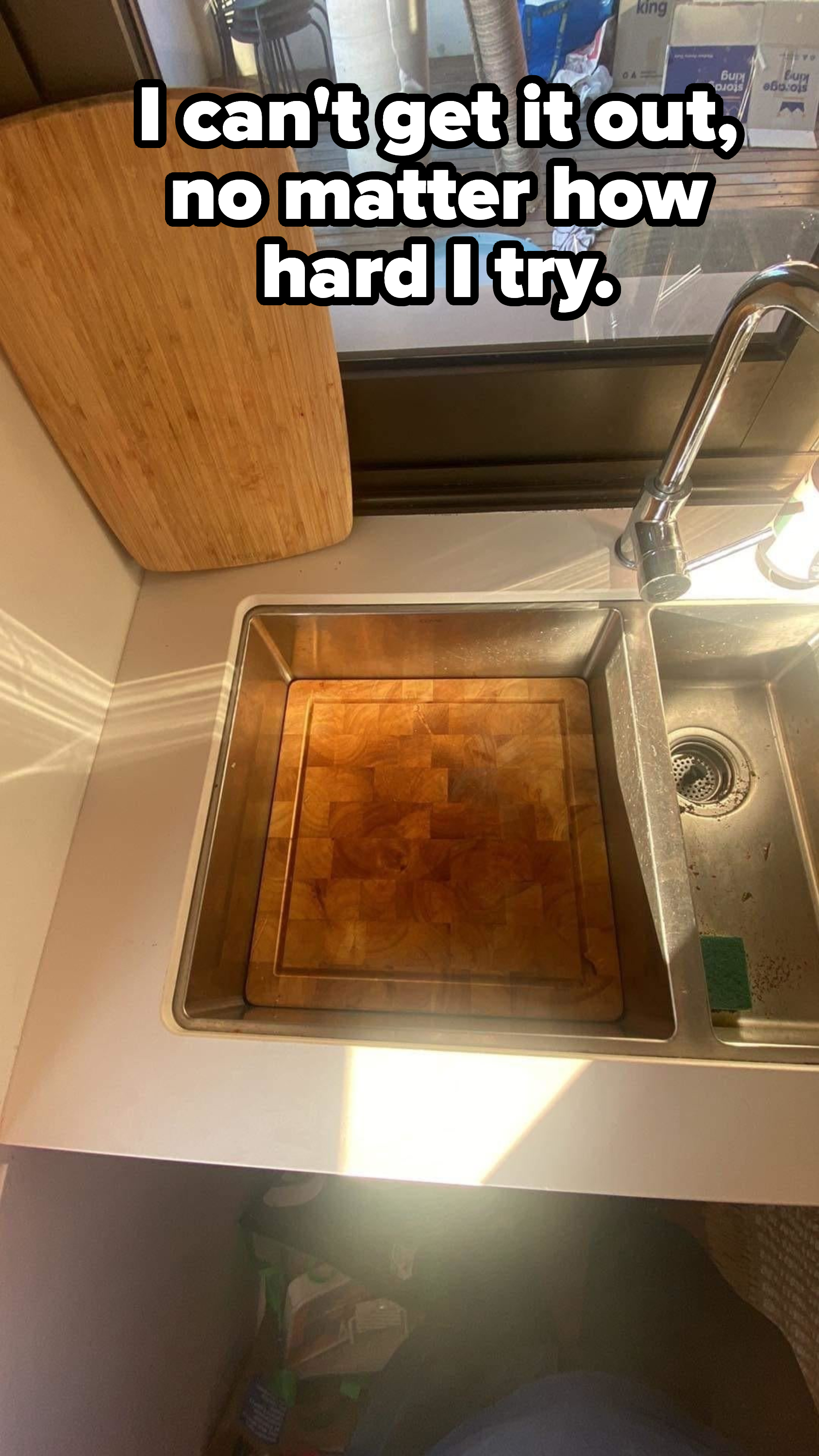 A cutting board stuck in a sink