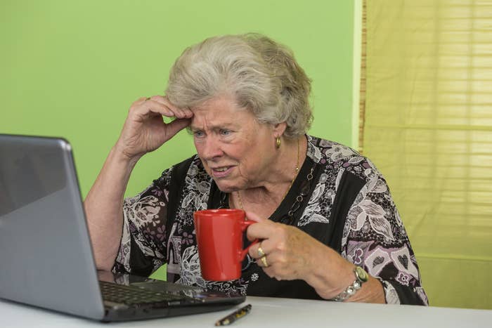 older woman drinking coffee at her laptop