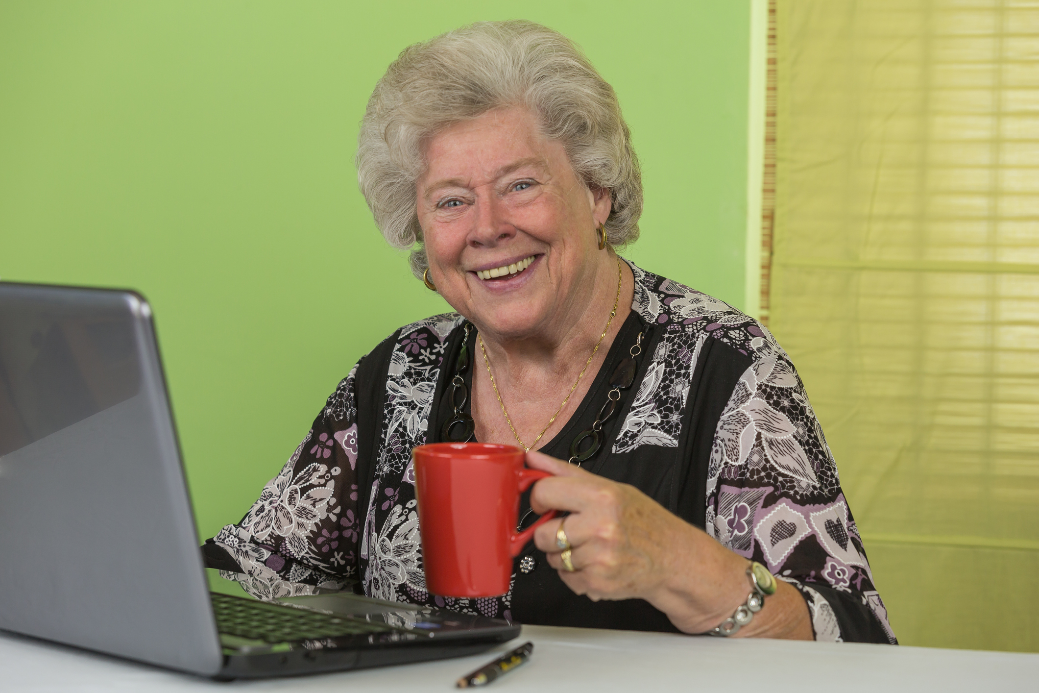 older woman smiling at her computer