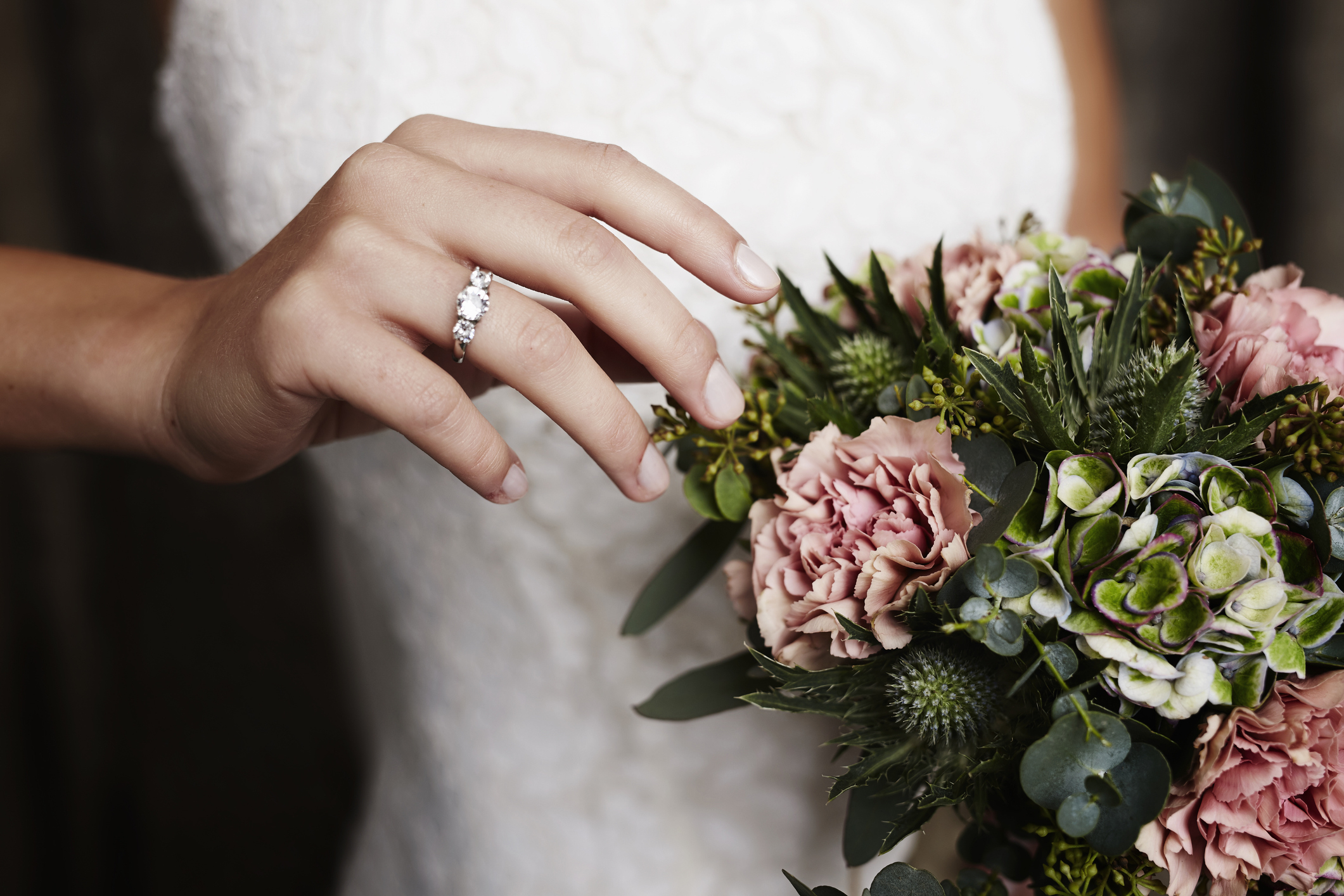 closeup of a ring finger and a bouquet