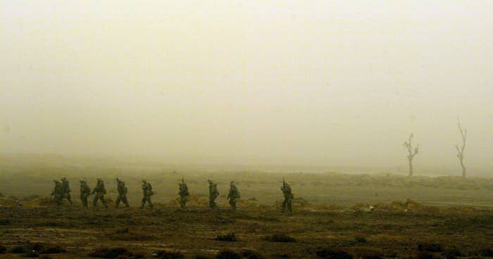 Soldiers march together through fog