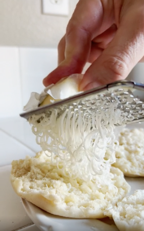 Someone using a cheese grater on butter