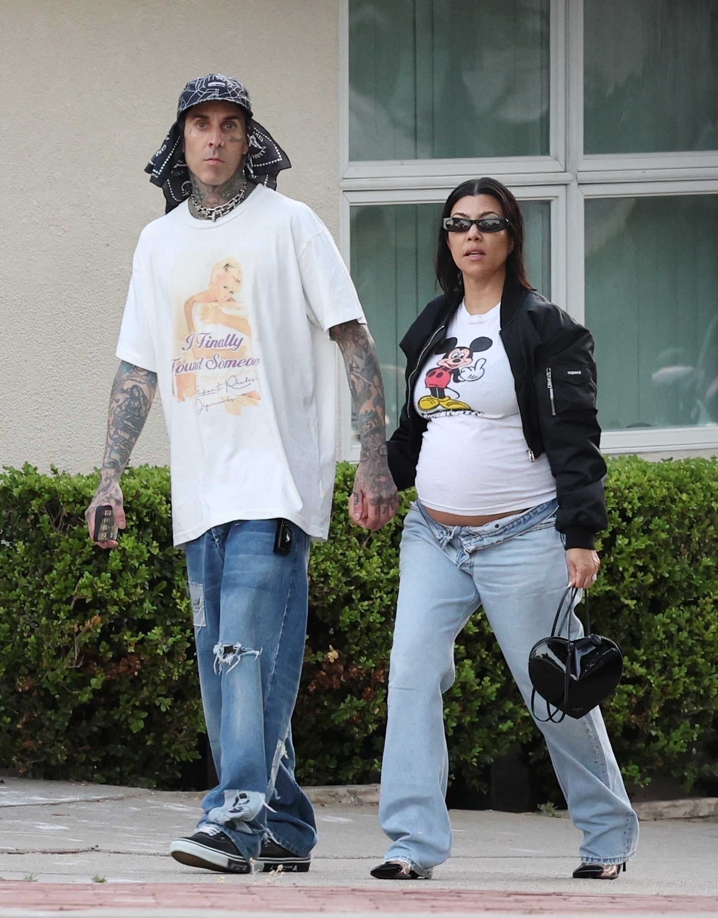 Travis Barker and Kourtney Kardashian walking outside