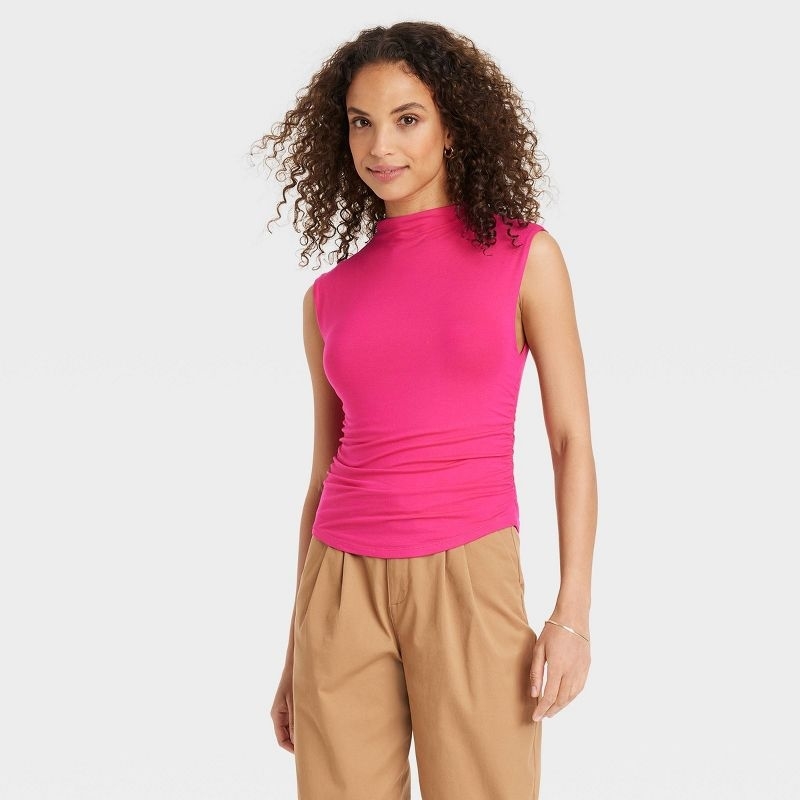 A reviewer in a pink top and brown bottoms