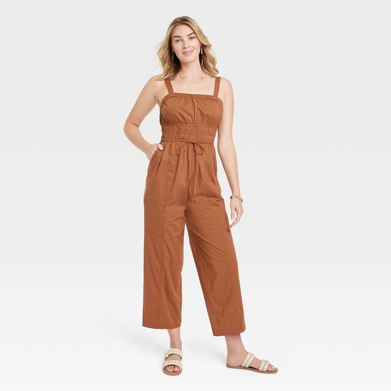 A model wearing a brown jumpsuit