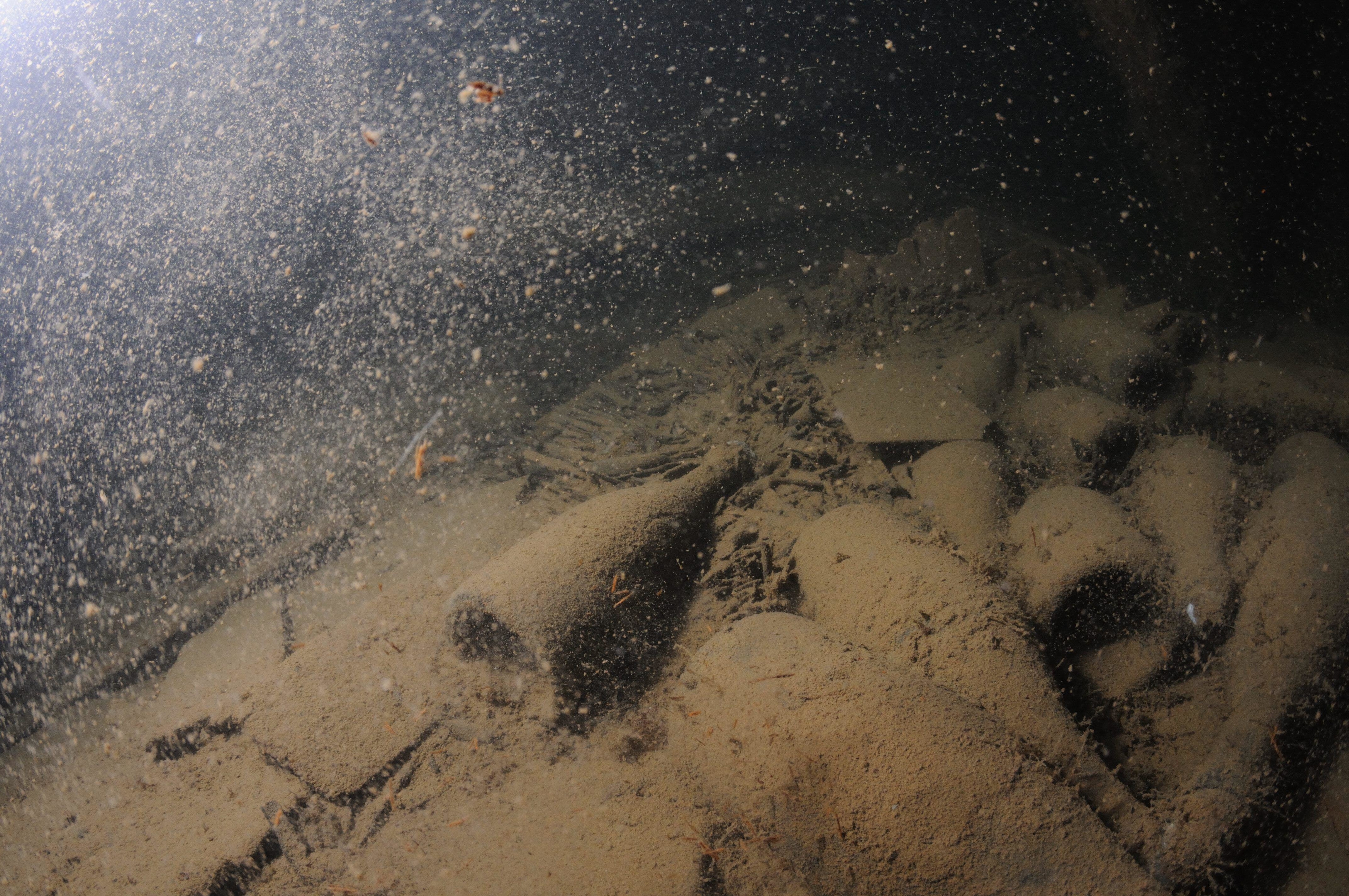 Bottles covered by thick debris at the bottom of an ocean