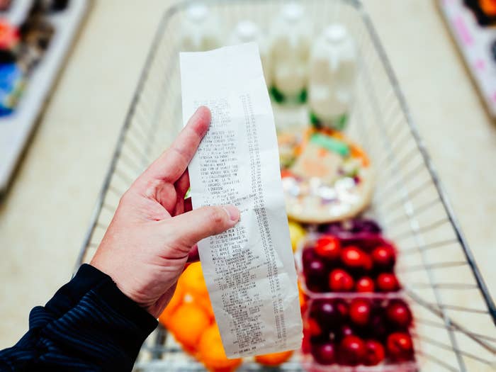 Someone holding up their grocery receipt