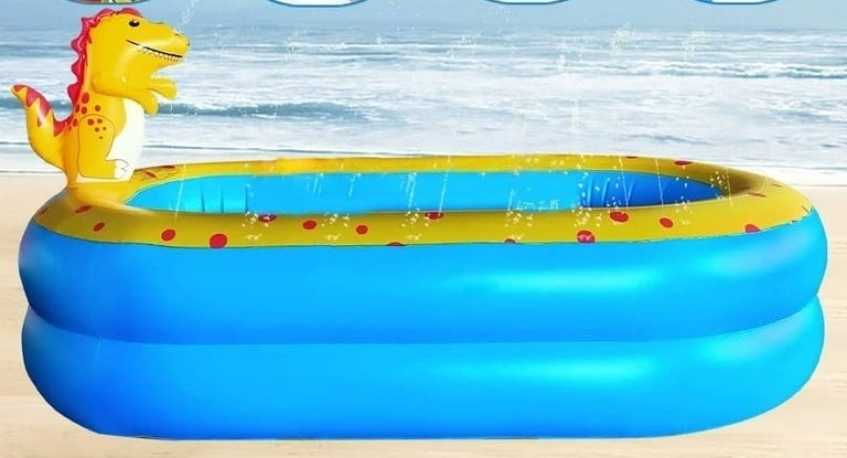 Inflatable kiddie pool with a playful dinosaur design, featuring small water fountains, set on a beach background