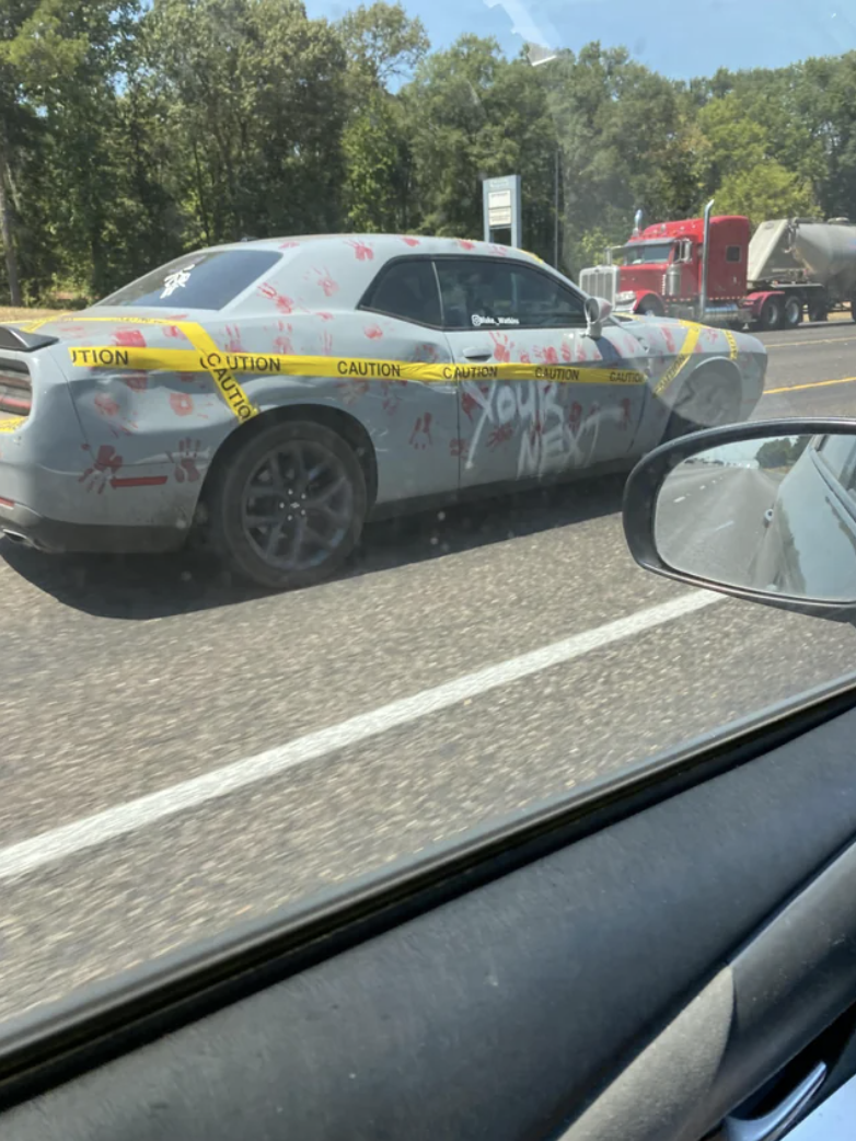 car wrapped in caution tape and bloody hand prints