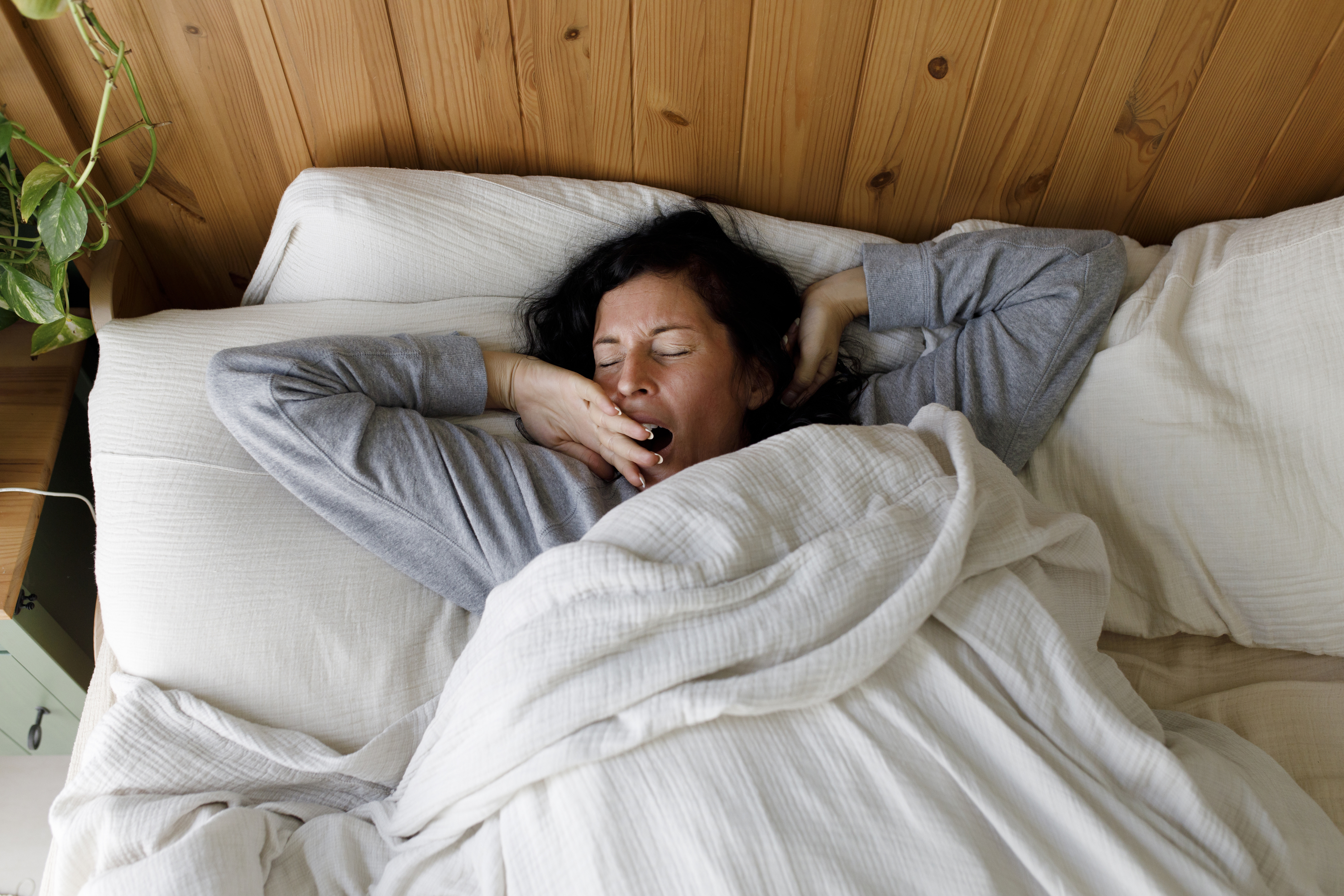 A woman yawning in bed