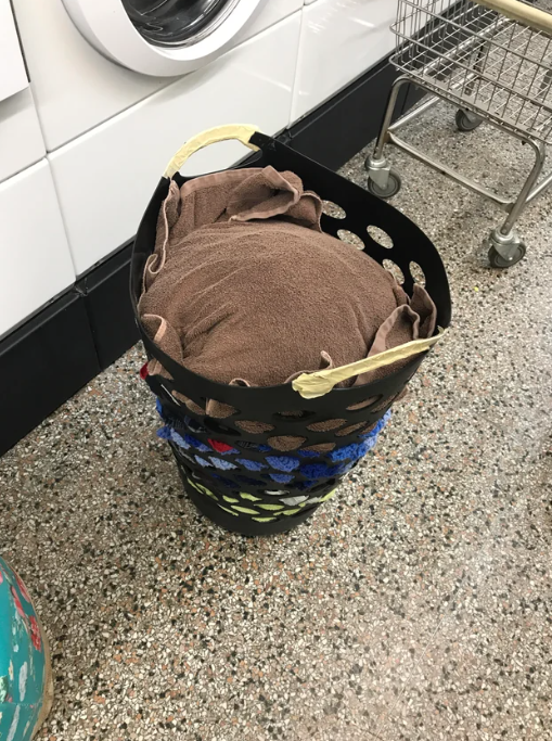 A towel tucked into the top of a laundry basket