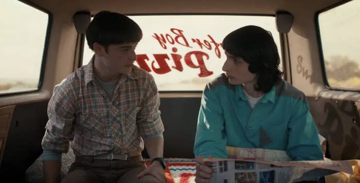 Noah Schnapp on a van with another character in a scene from "Stranger Things"
