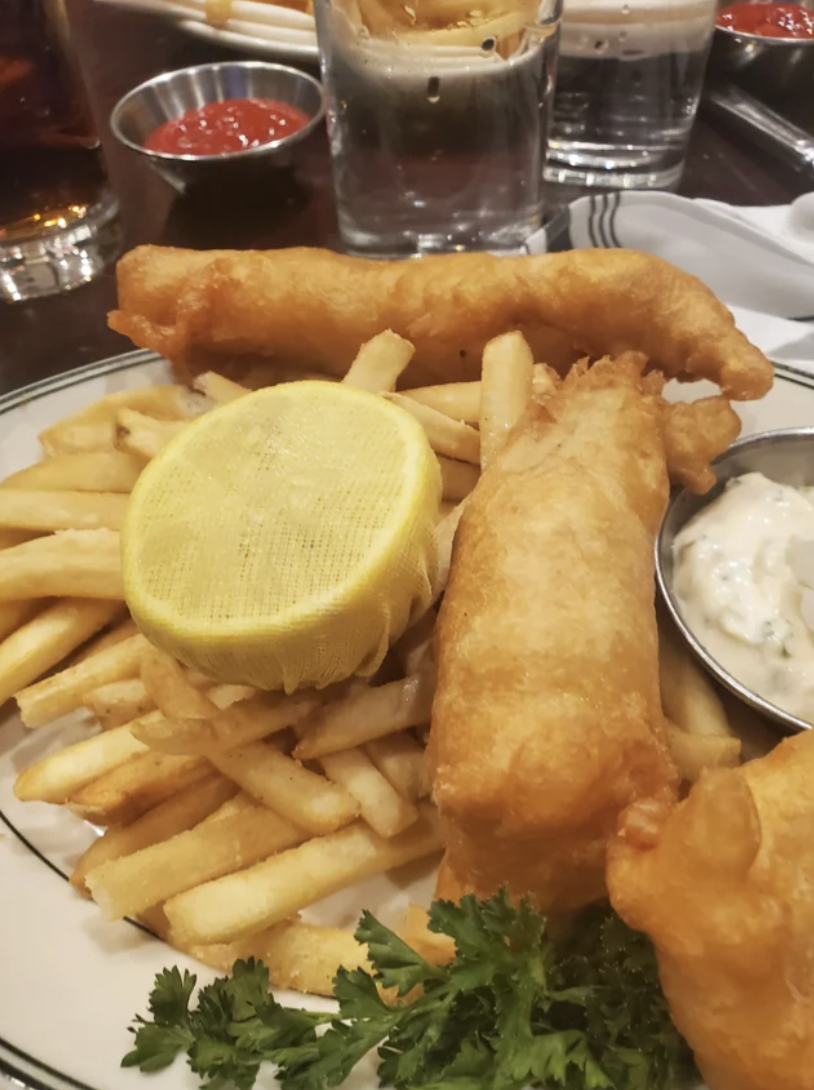 Mesh over a lemon on a plate of fish and chips
