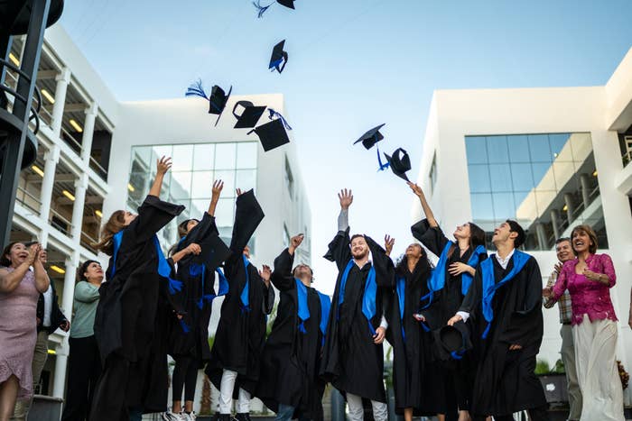 group of college grads throwing their hats into the air