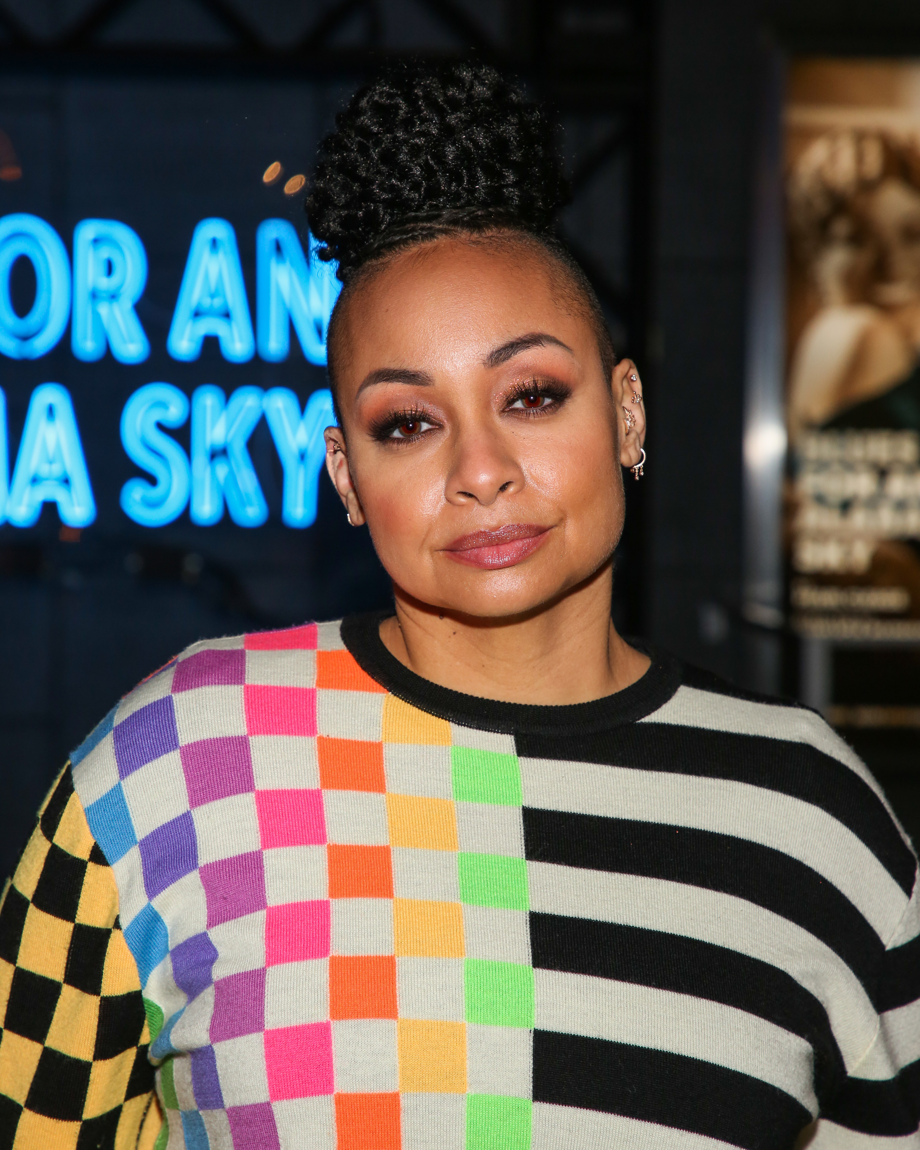 Close-up of Raven-Symoné at a media event in a colorful print top