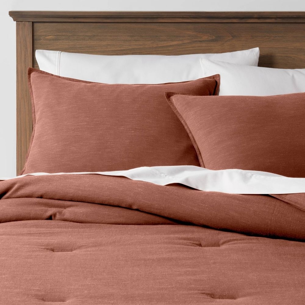 The comforter and shams in Cognac on a bed