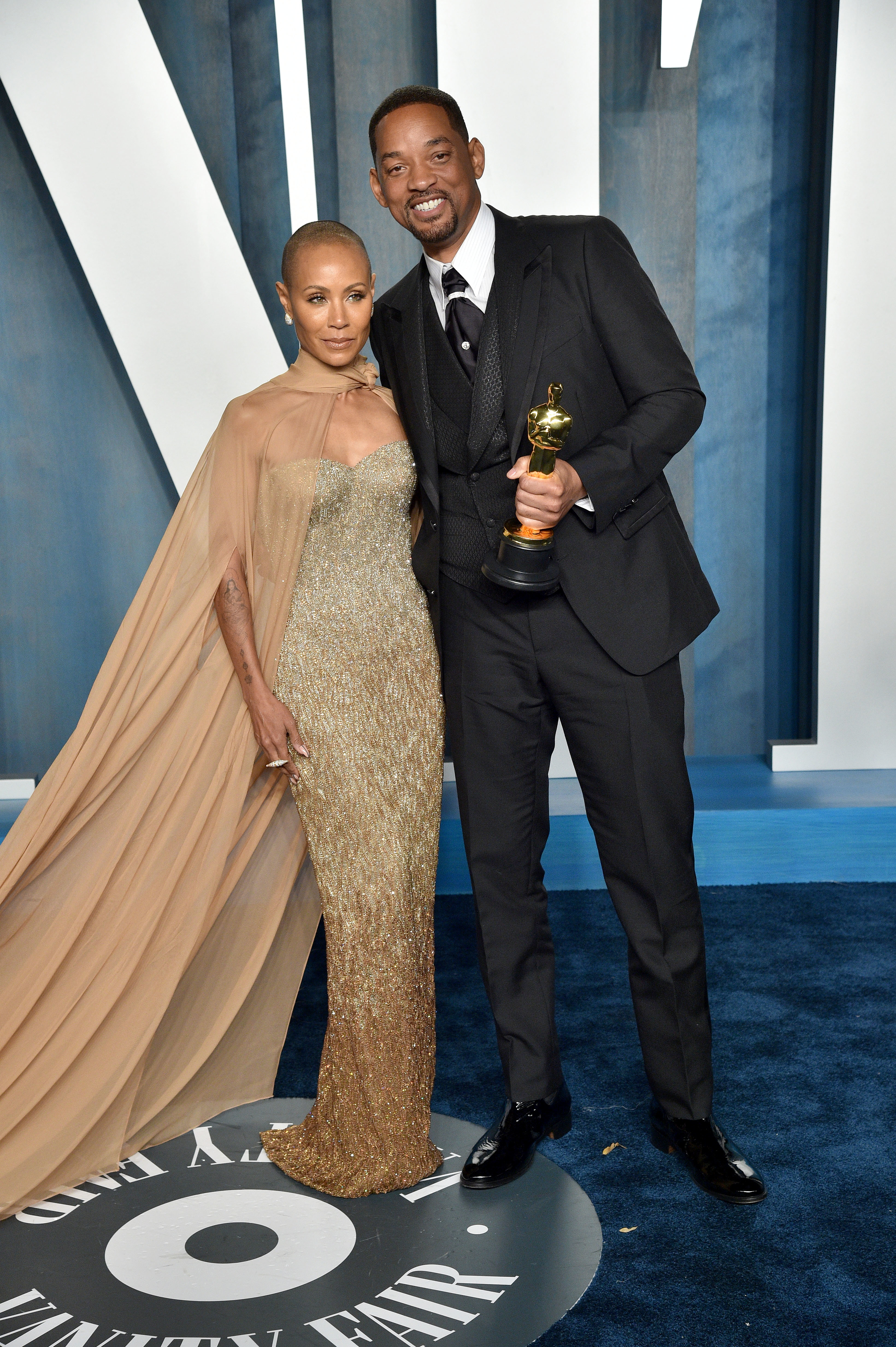 Close-up of Jada and Will, who is holding an award, at a media event