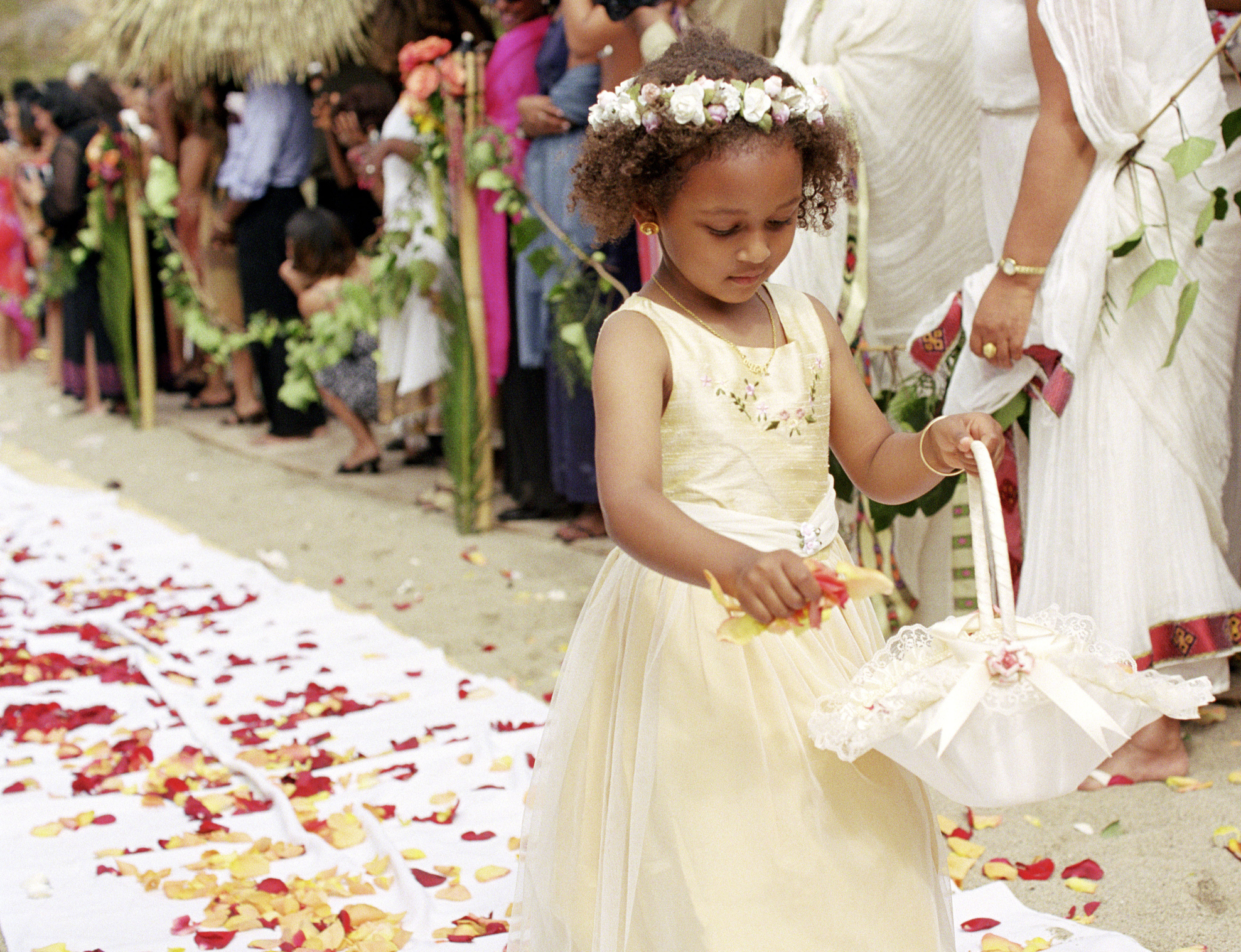 A flower girl throwing flowers on the aisle