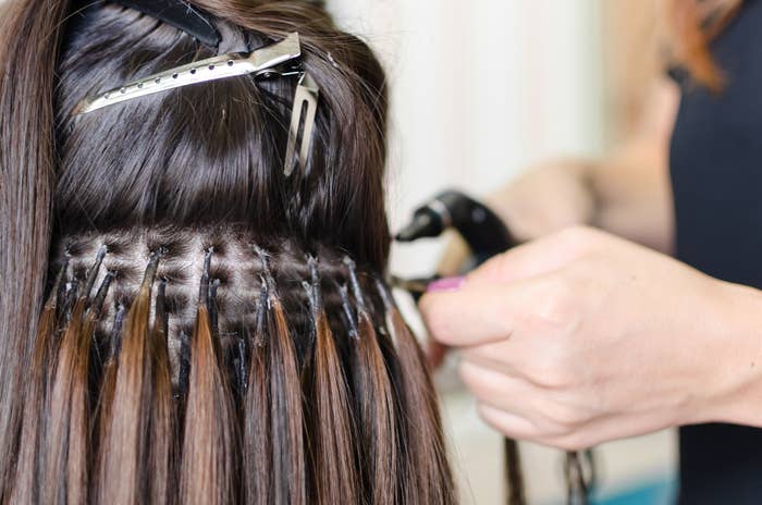 Hair stylist putting extensions in hair