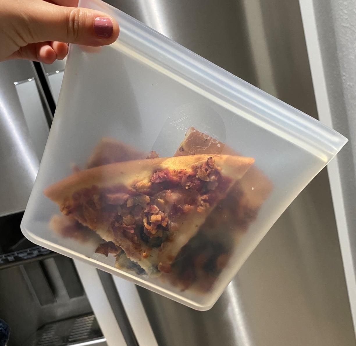Reviewer holding the reusable bag with pizza slices in it