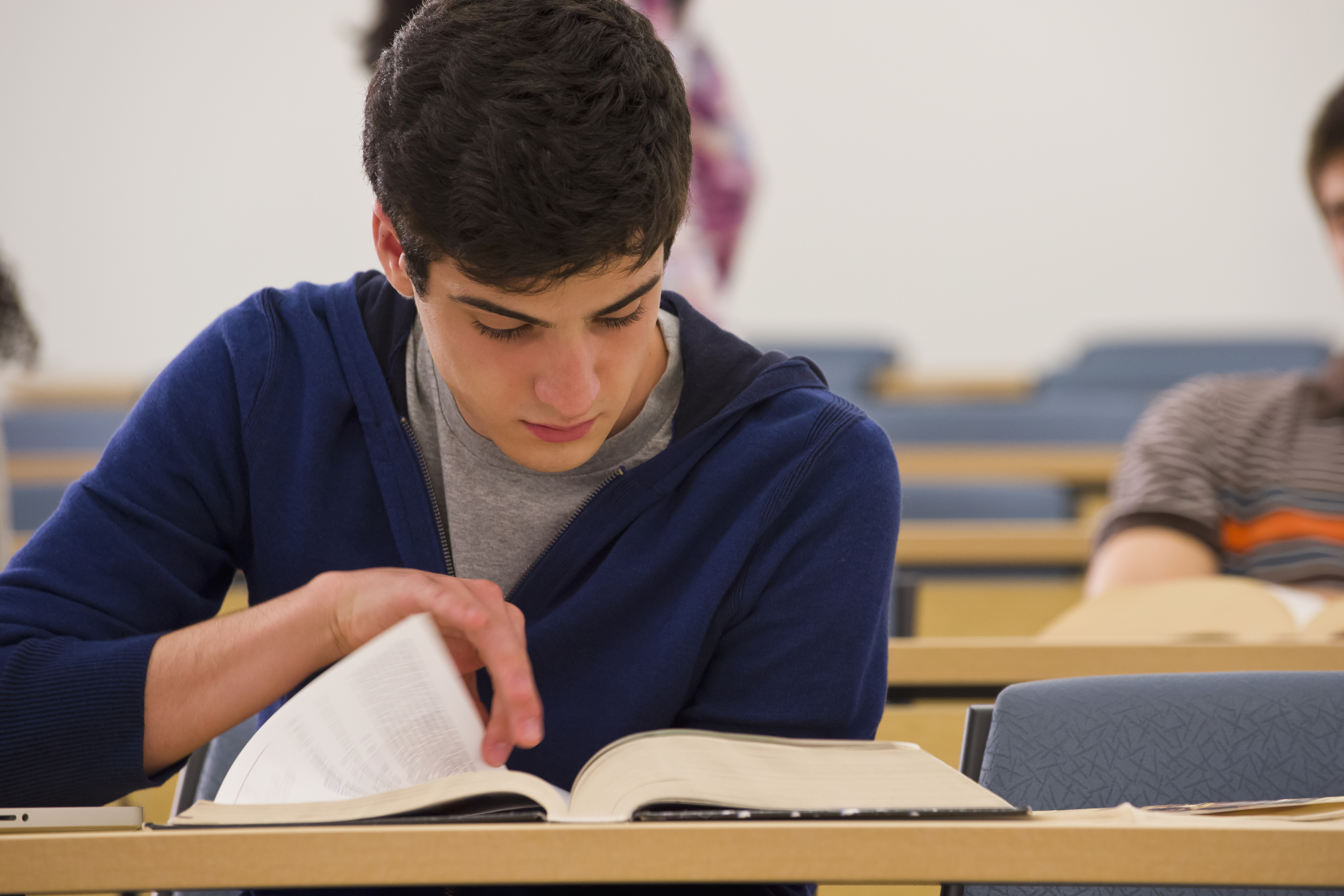 A student turning a page in a book
