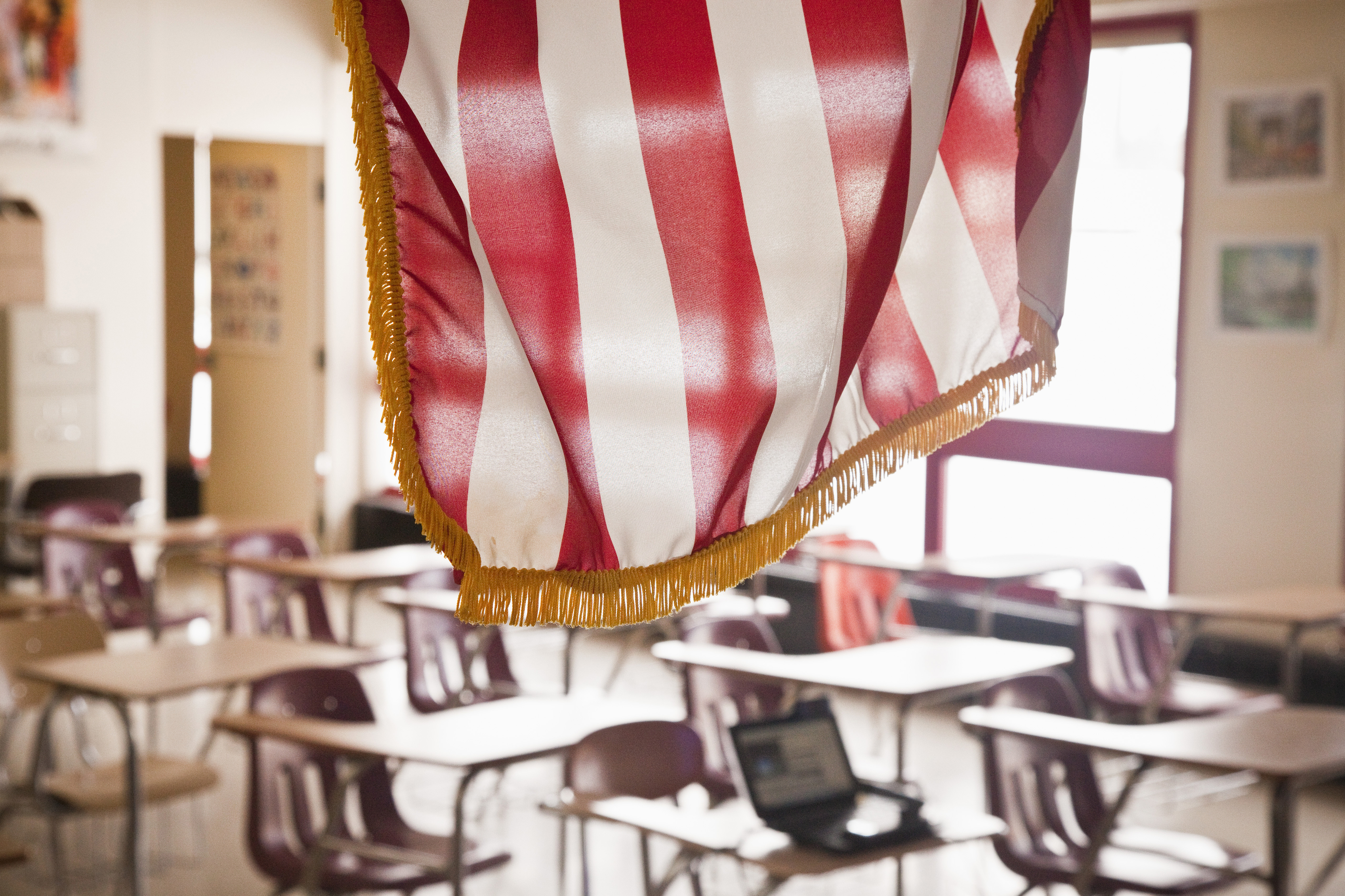 An empty classroom with an American flag in the foreground