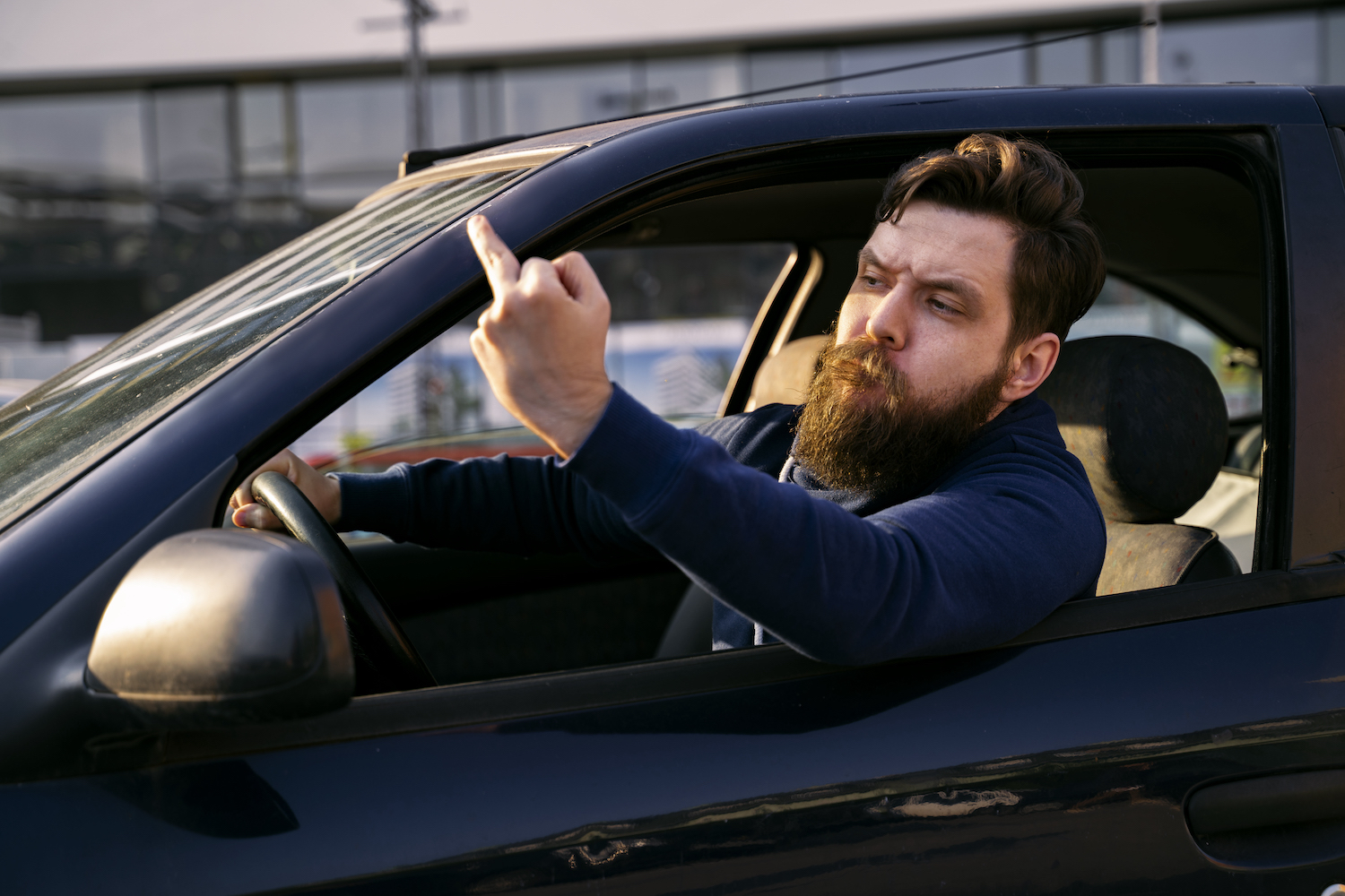 A man giving someone else the finger while driving