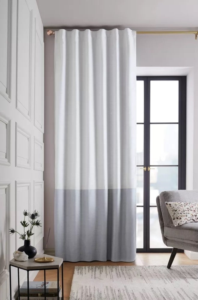 Color blocked white and gray curtain panel hanging in a living room