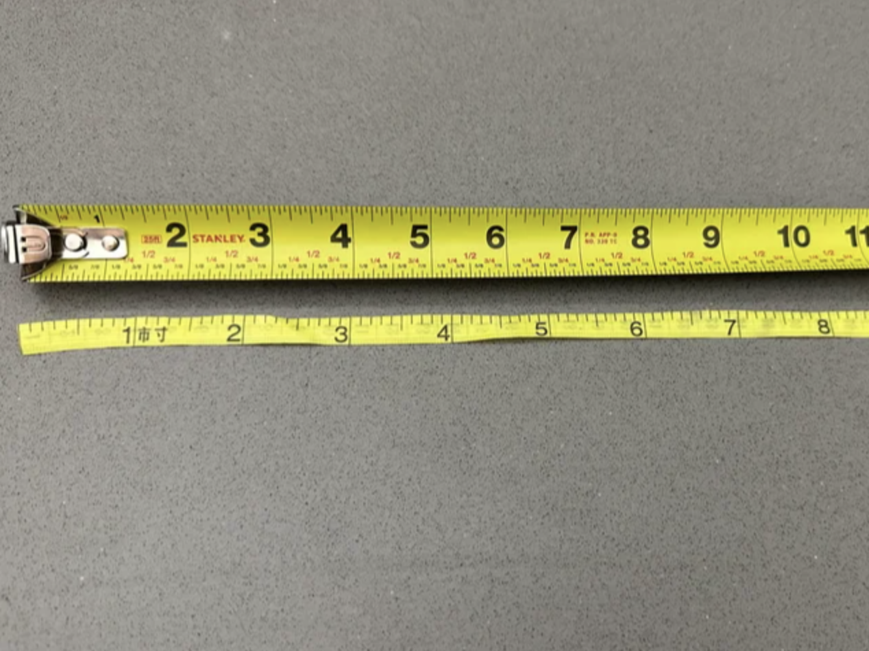 measuring tape next to ruler with the measurements all off