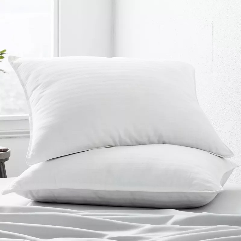 Two white pillows on white bedsheets