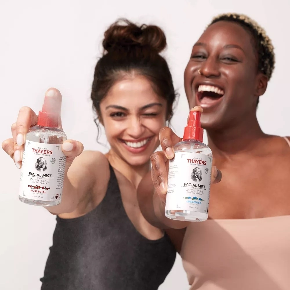 Two people holding the bottles of Thayers facial mist