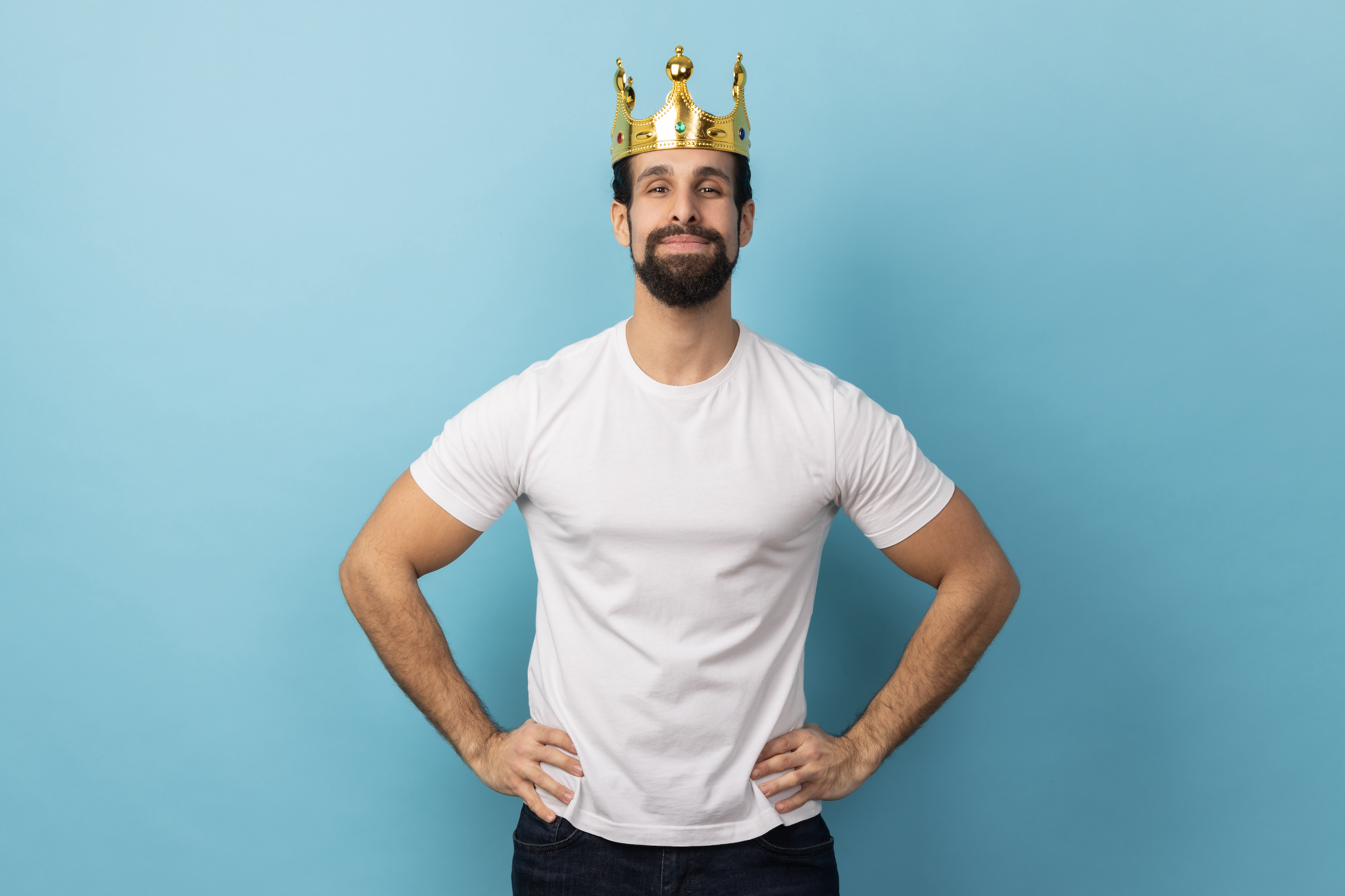 A man wearing a crown while having his hands on his waist
