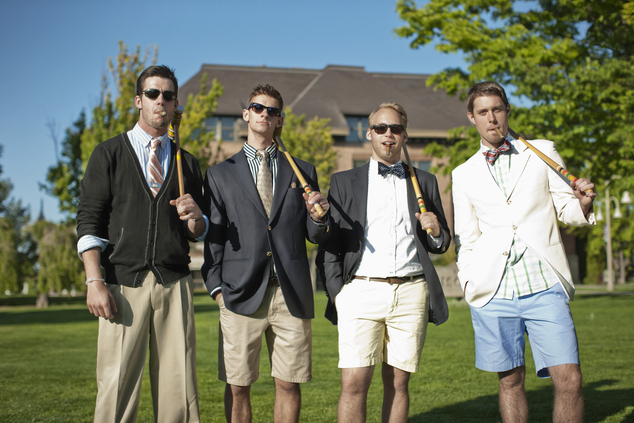 Wealthy-looking young men in blazers and holding croquet mallets