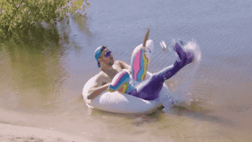 A man splashing in the water while on a floatie