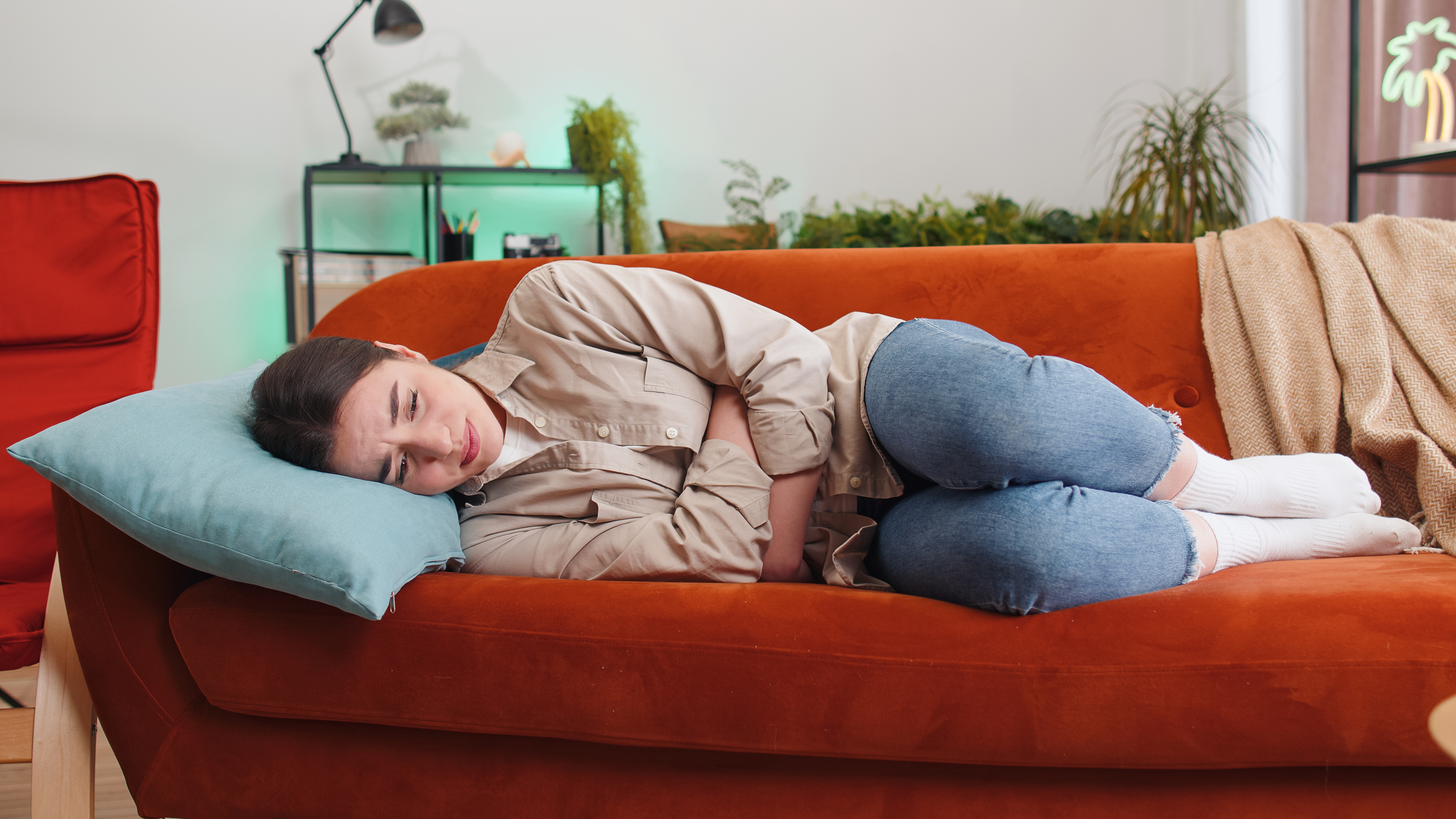 A woman with cramps laying on a couch