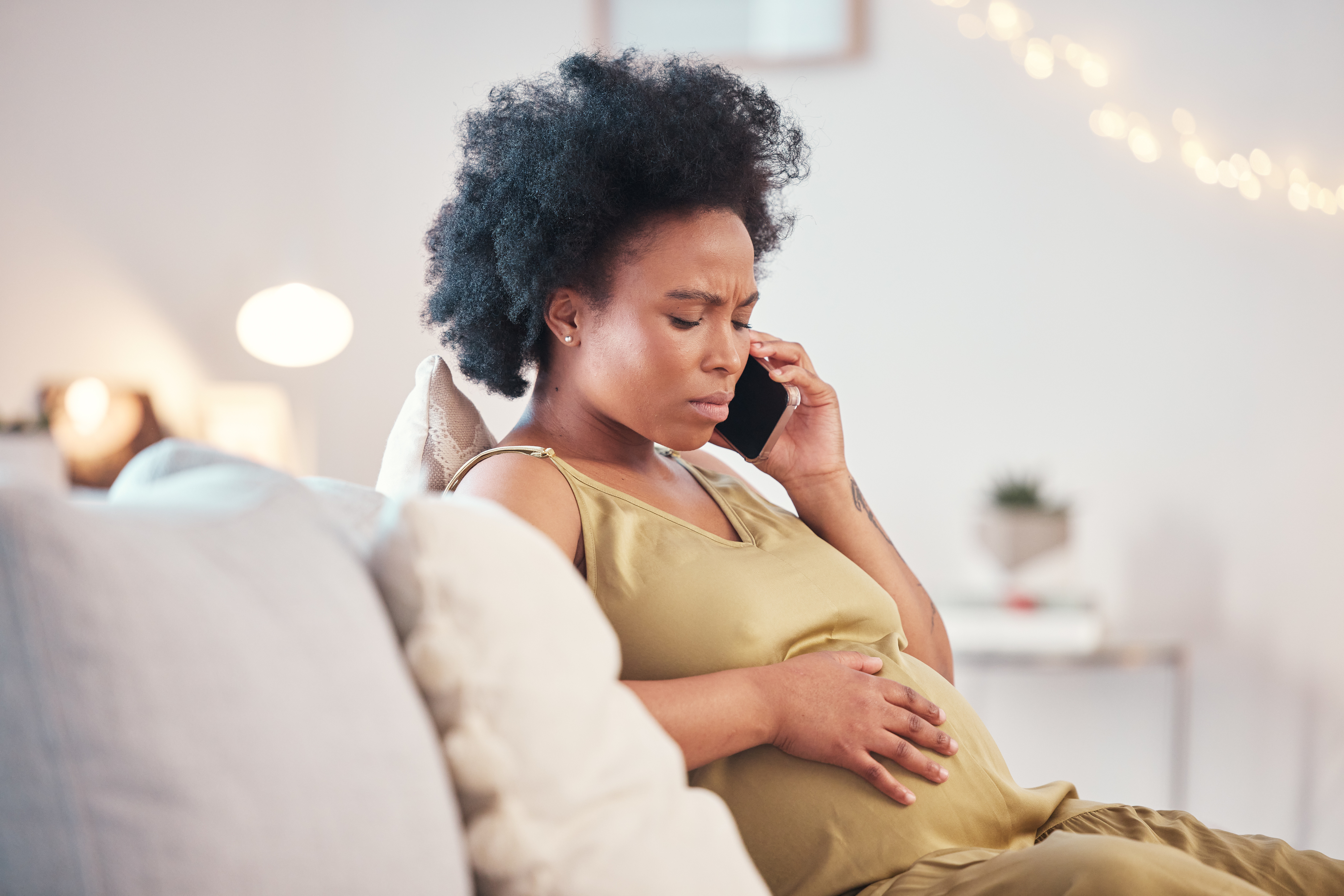 a worried pregnant woman on the phone