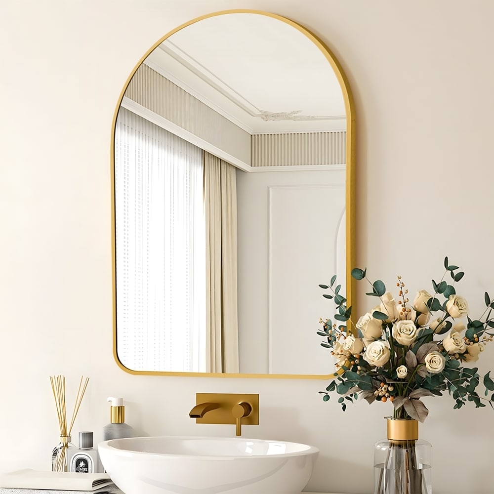 the gold arched mirror over a sink