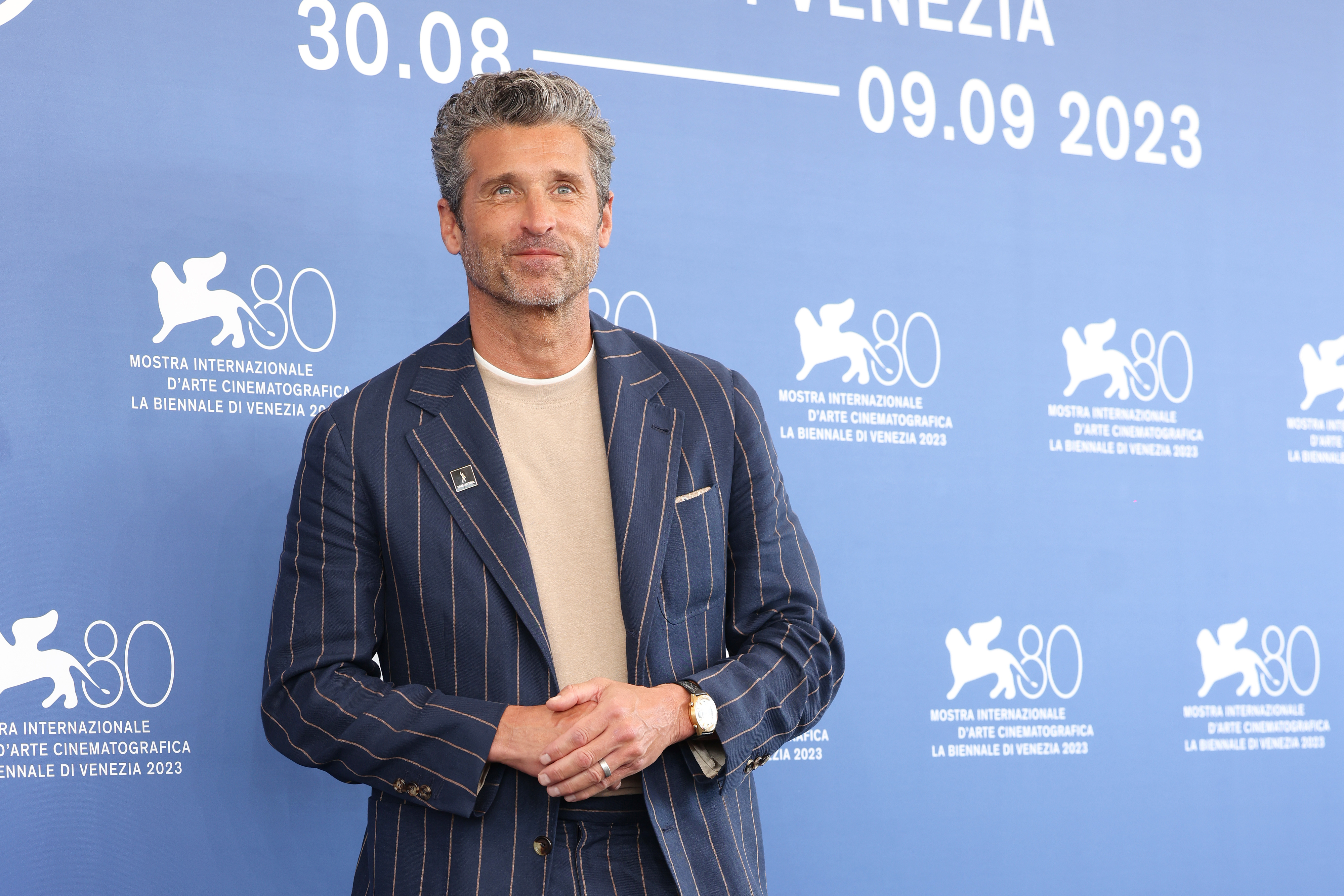 Close-up of Patrick at the festival, wearing a pin-striped suit and T-shirt