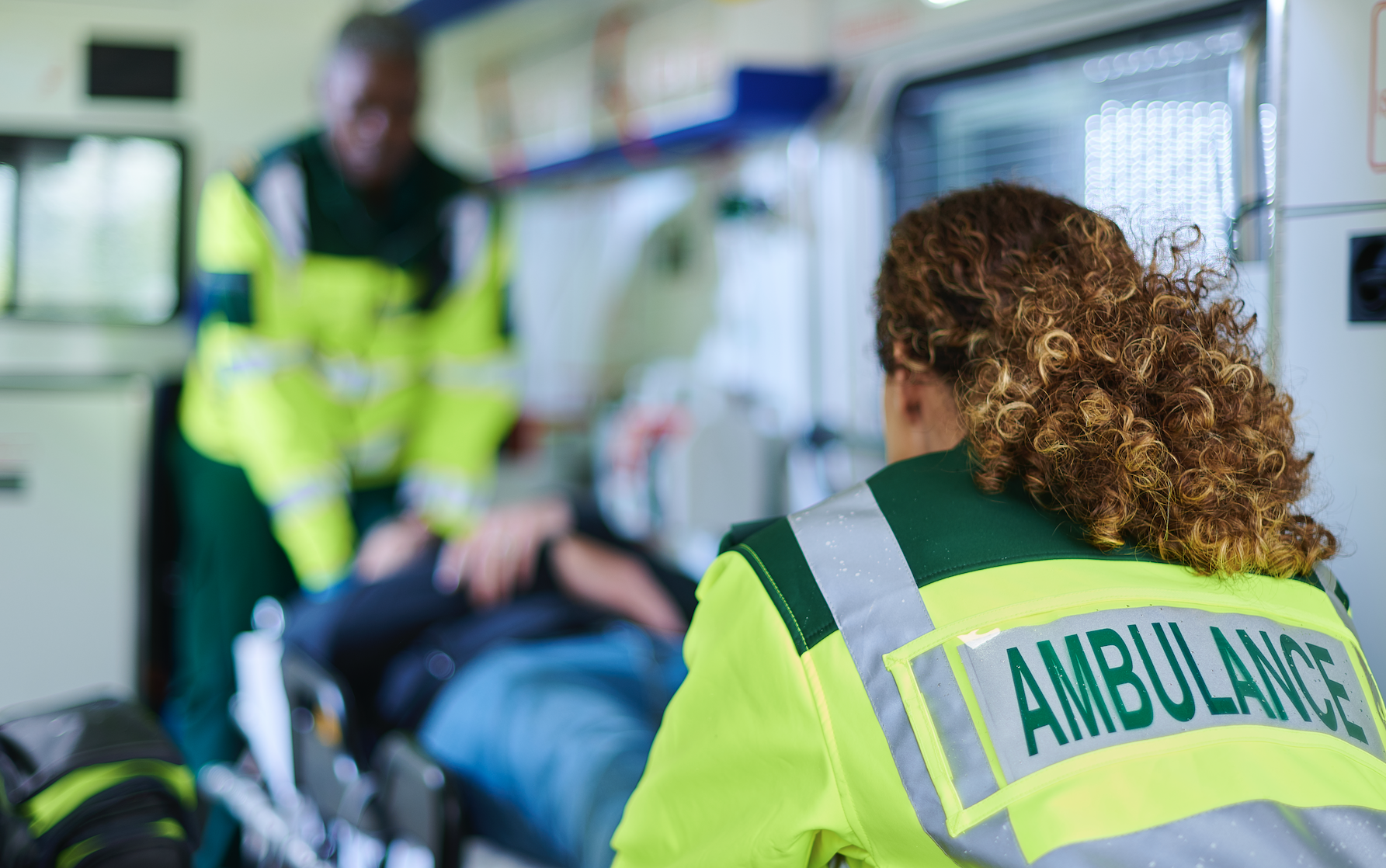 two EMTs rolling a patient
