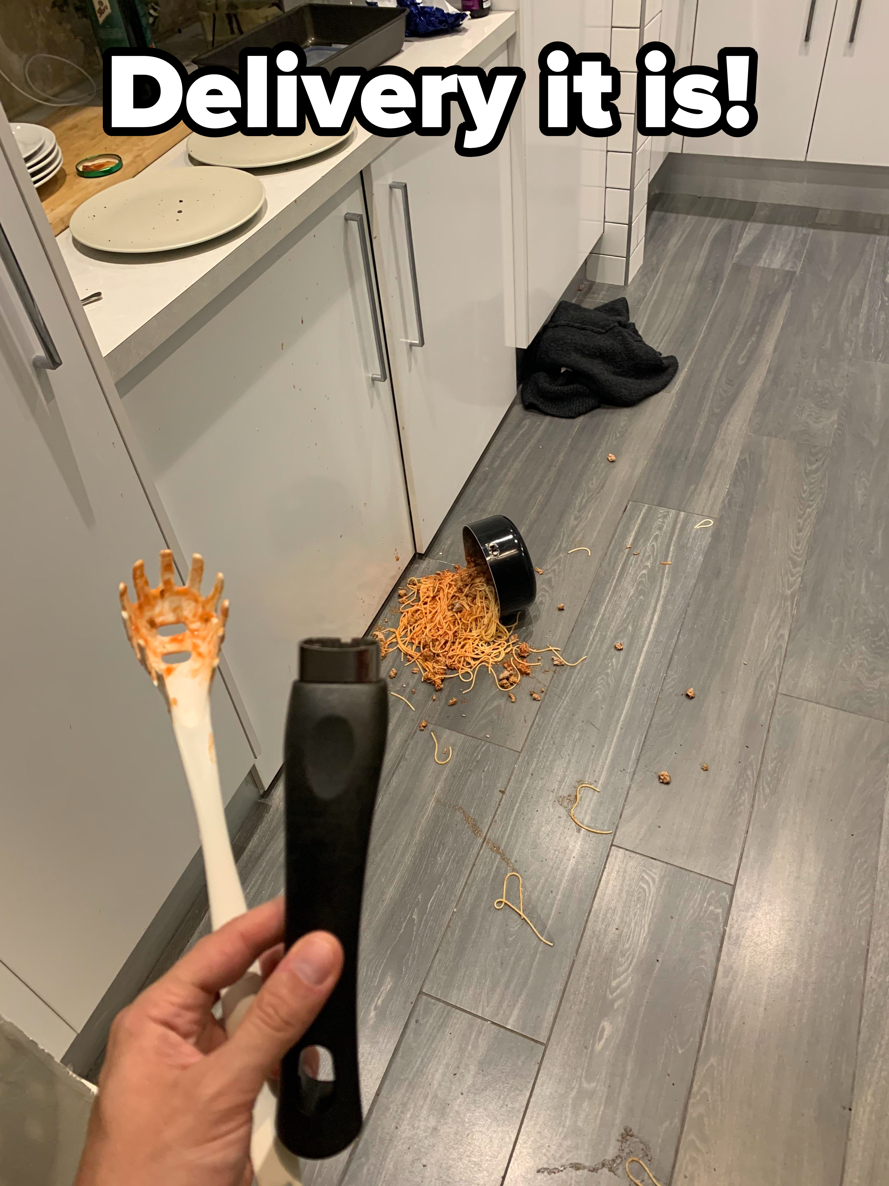 Handle of a pot containing spaghetti breaks, with the spaghetti all over the kitchen floor, with caption &quot;Delivery it is!&quot;