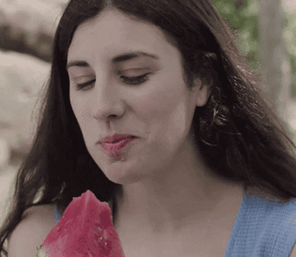 woman eating watermelon and looking to the side
