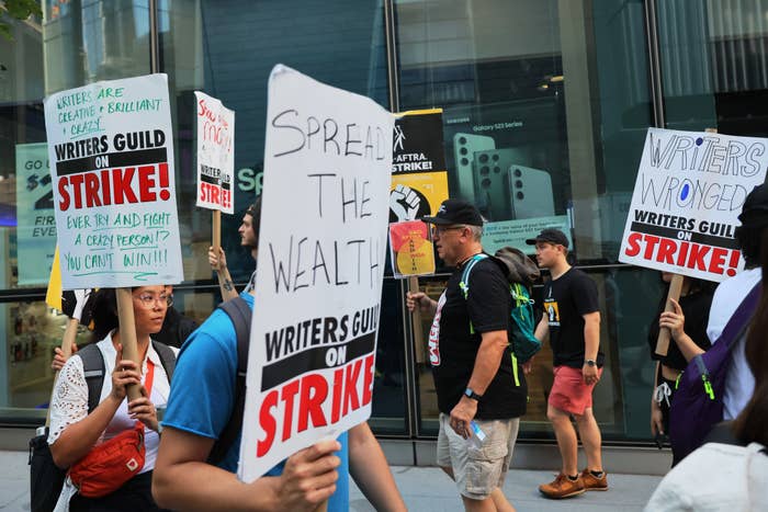 Writers walking a picket line holding signs