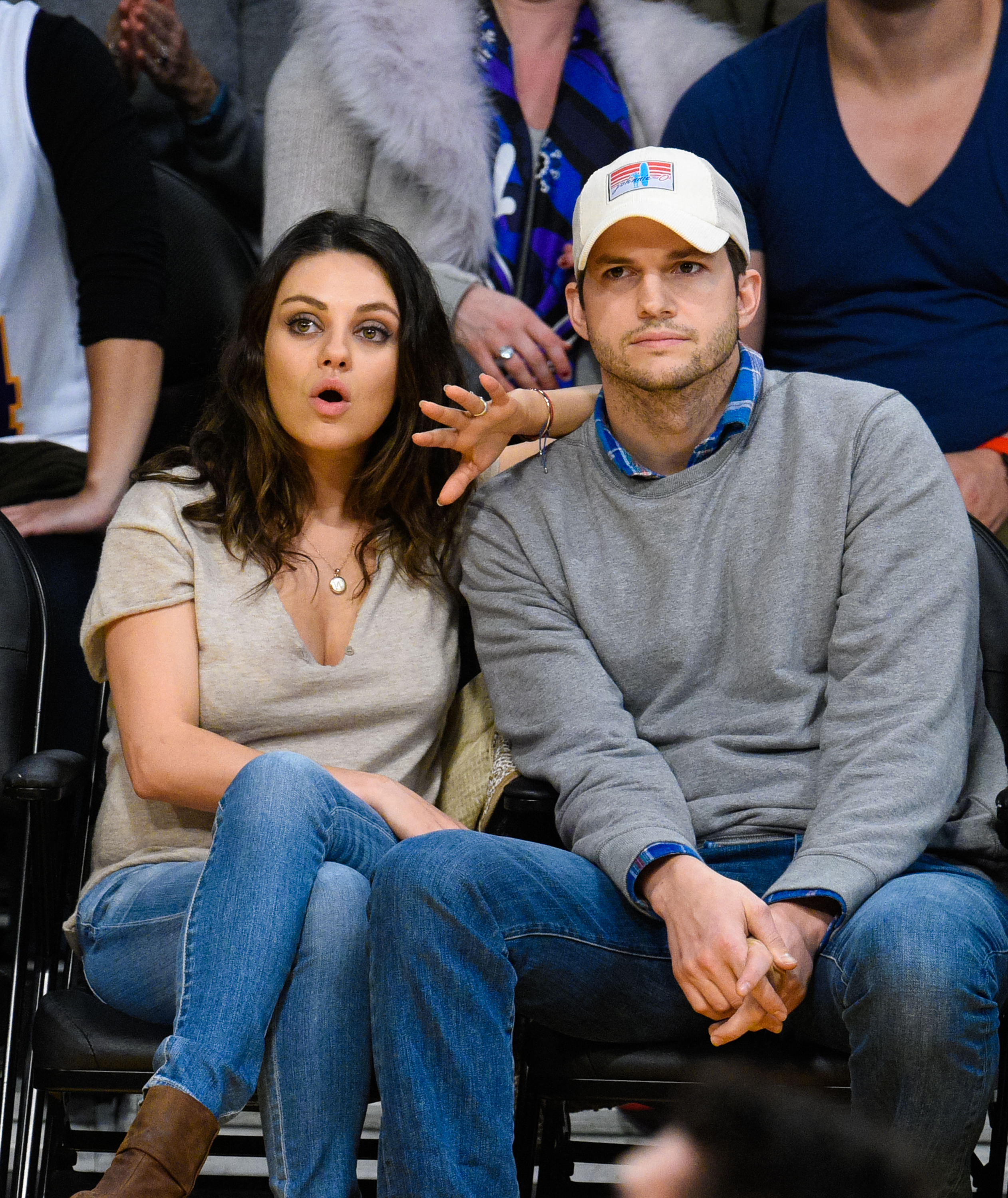 Close-up of Ashton and Mila sitting together in an audience