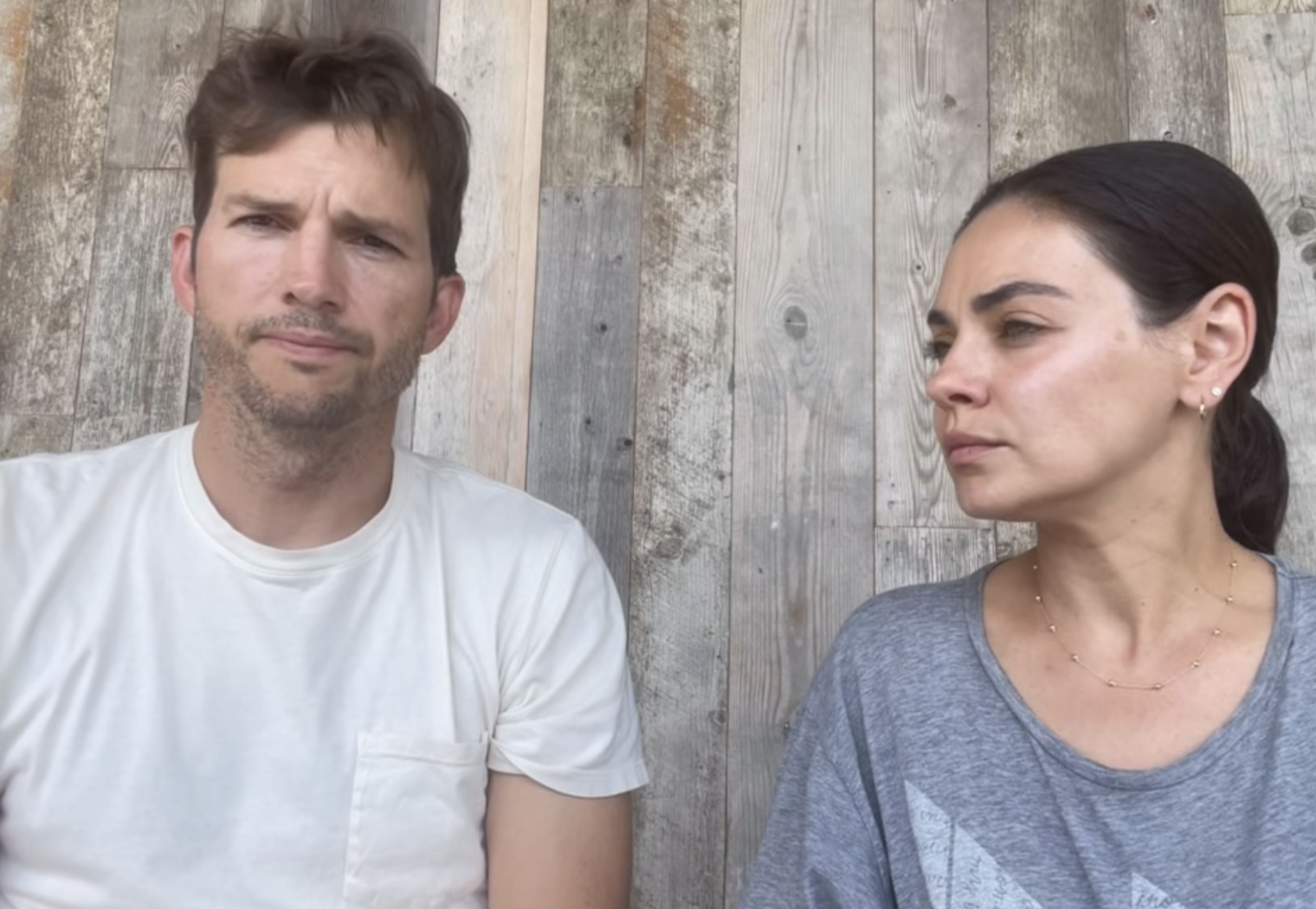 Close-up of Ashton and Mila looking serious in the video