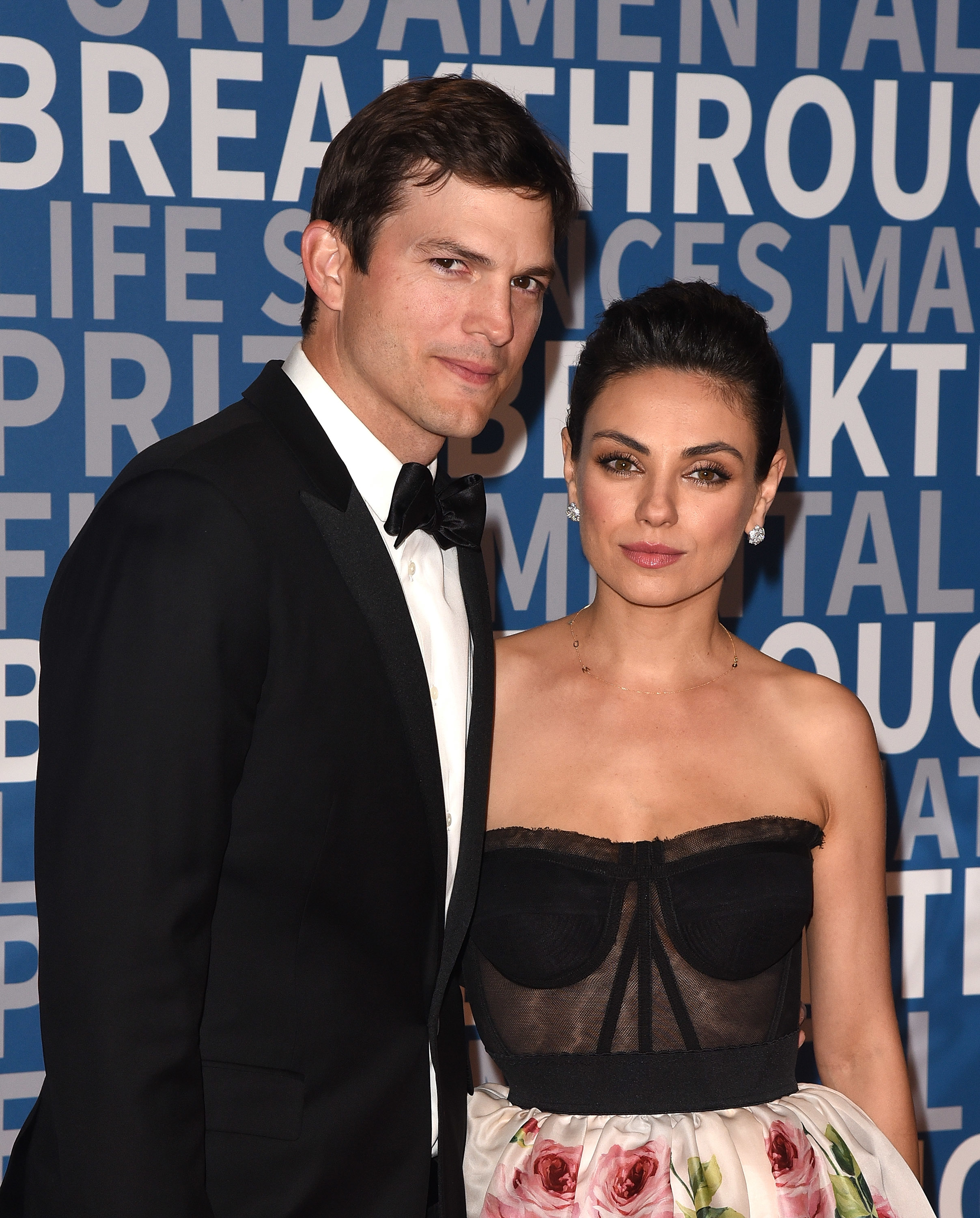 Close-up of Ashton and Mila at a media event