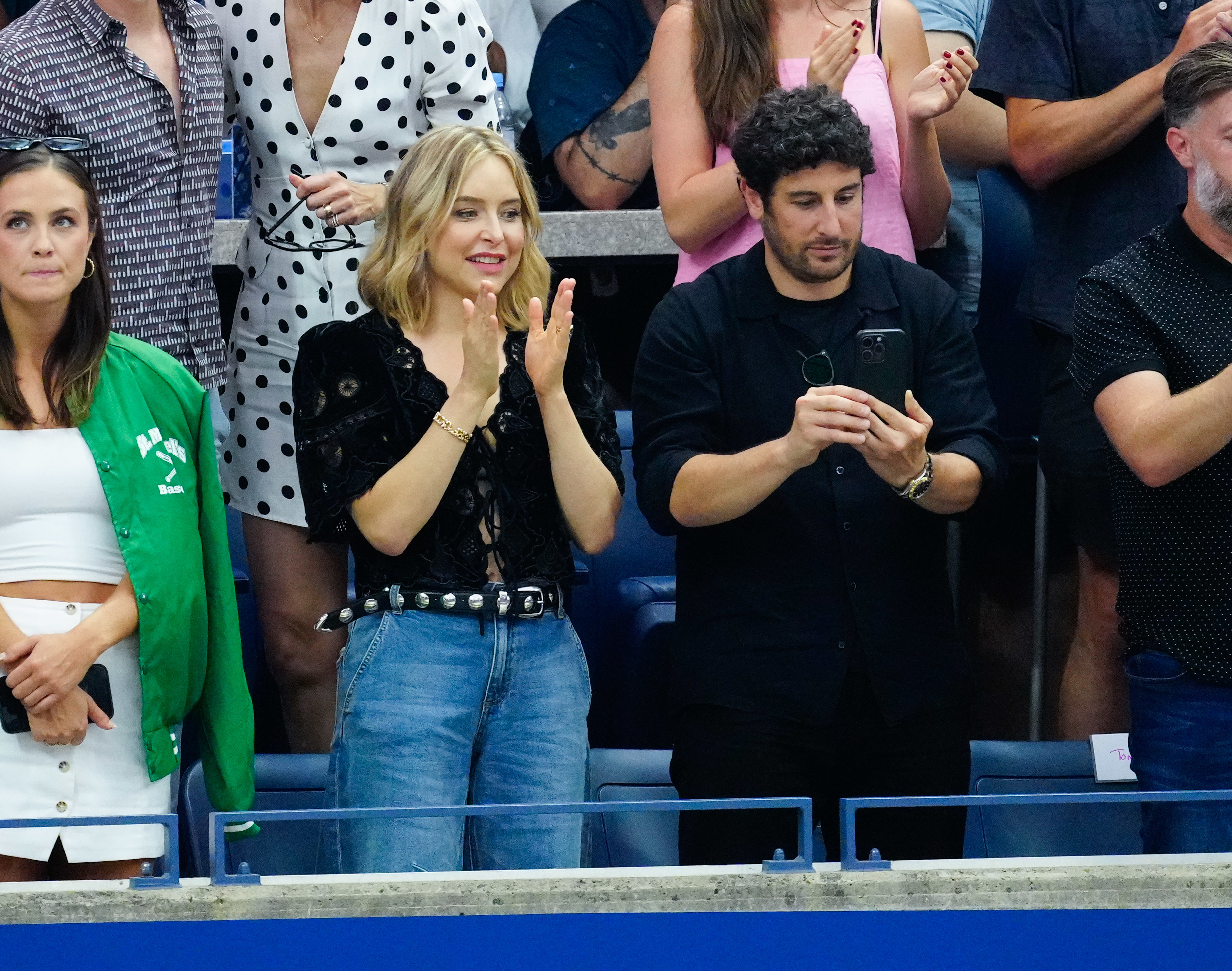 Jason Biggs takes a picture of the players as he and Jenny Mollen stand