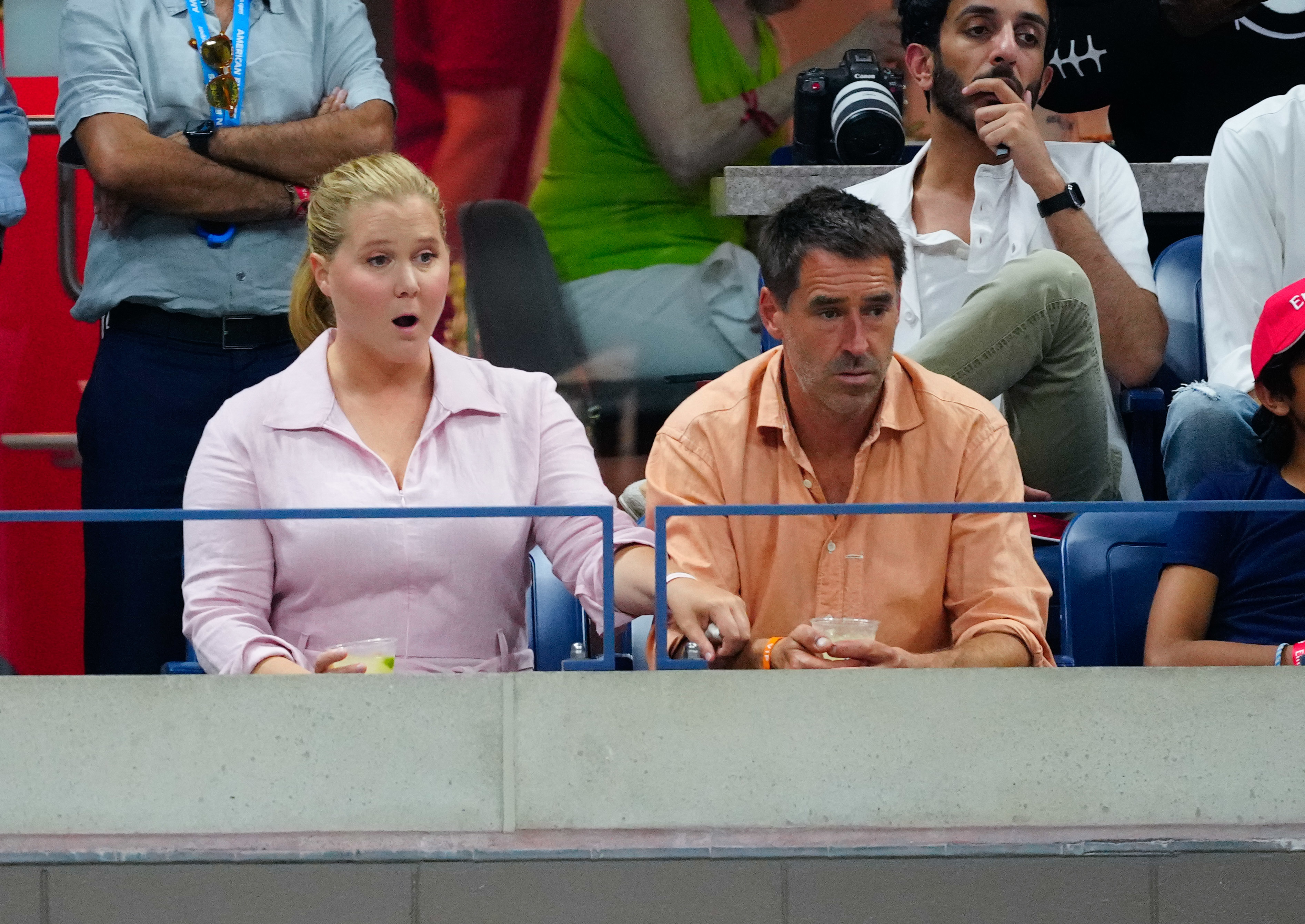 Amy Schumer looking astonished watches the match with her husband Chris Fischer